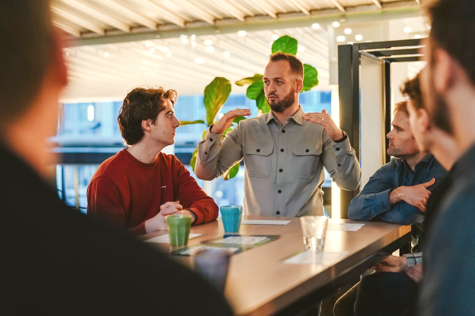 Groep professionals in gesprek aan een tafel tijdens een training