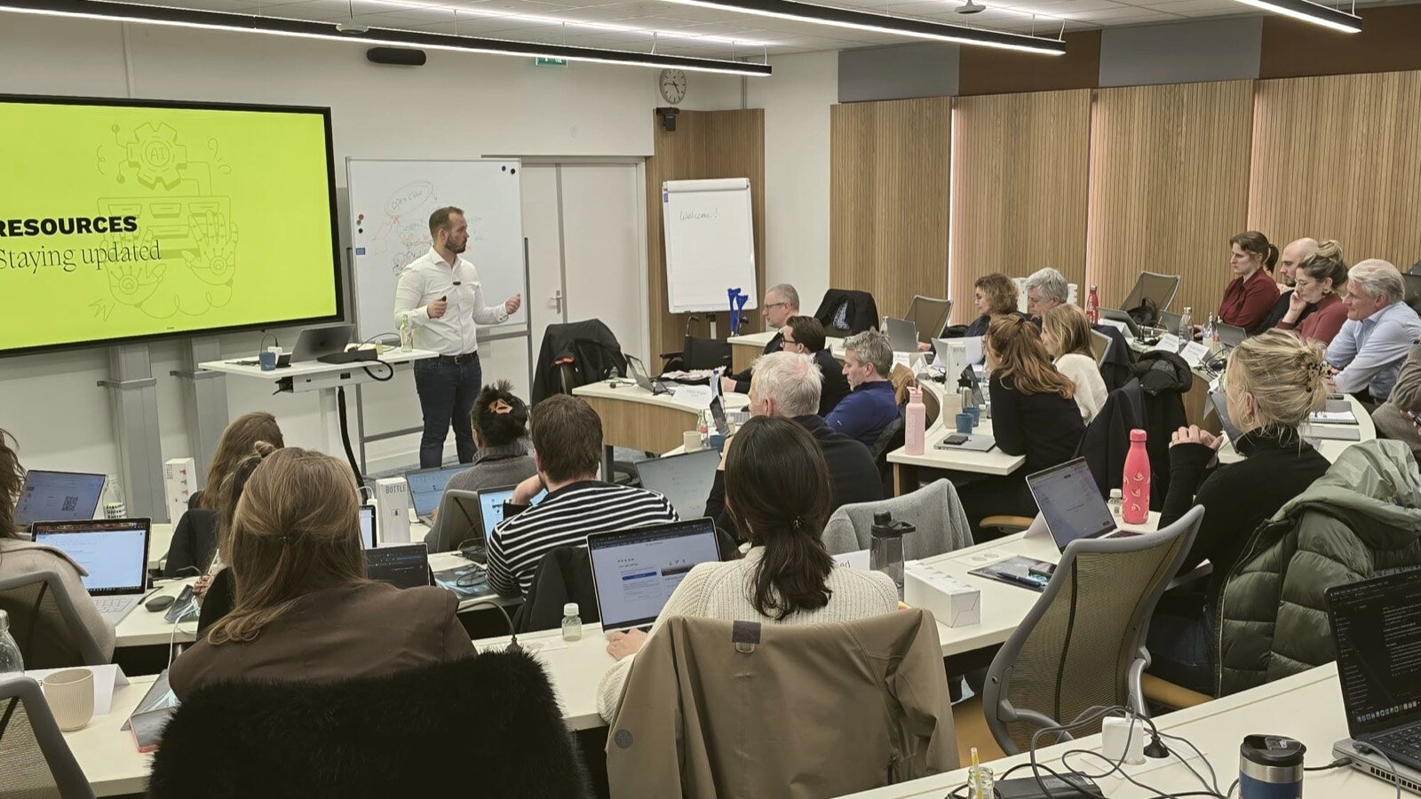 Grote groep deelnemers tijdens een training in een leszaal